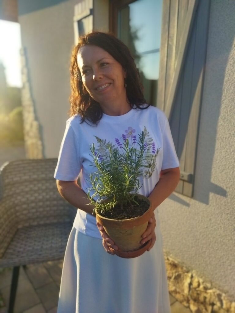 życie bliżej natury, zielarka z doniczką z rozmarynem w dłoniach
